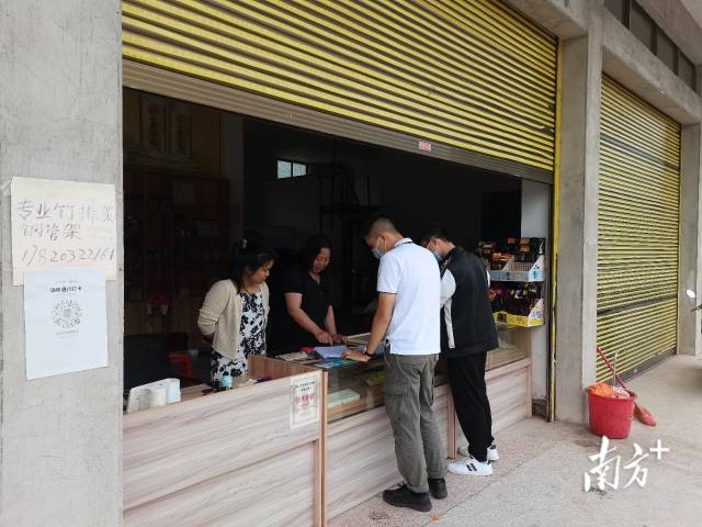 執(zhí)法人員給商家細致解釋政策。